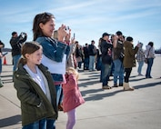 Eleven-year-old Michaela Sizek and 3-year-old Mya Sizek wait with their mother, Emily Sikes, for Spc. Austin Sikes to get off the airplane after arriving home from a Middle East deployment.
