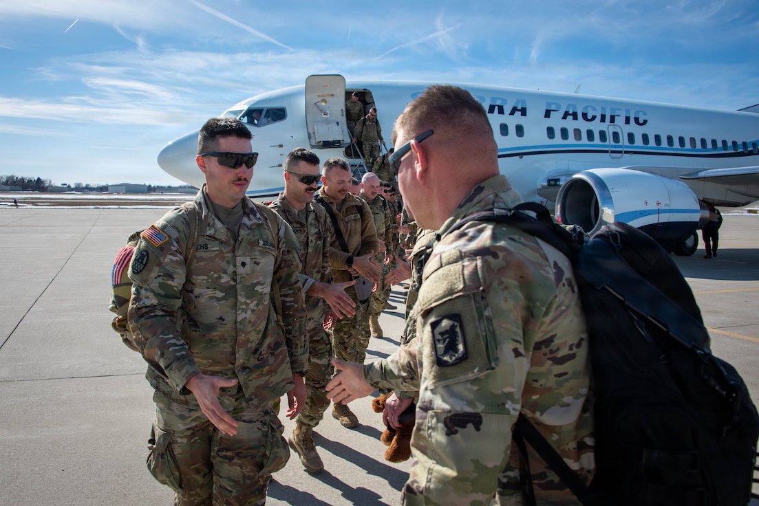 Illinois Army National Guard soldiers exit the plane after arriving home from a deployment.