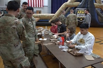 Members of the Ensign family(center) try a meal, ready-to-eat for lunch at the Sycamore Armory on February 7, 2026.