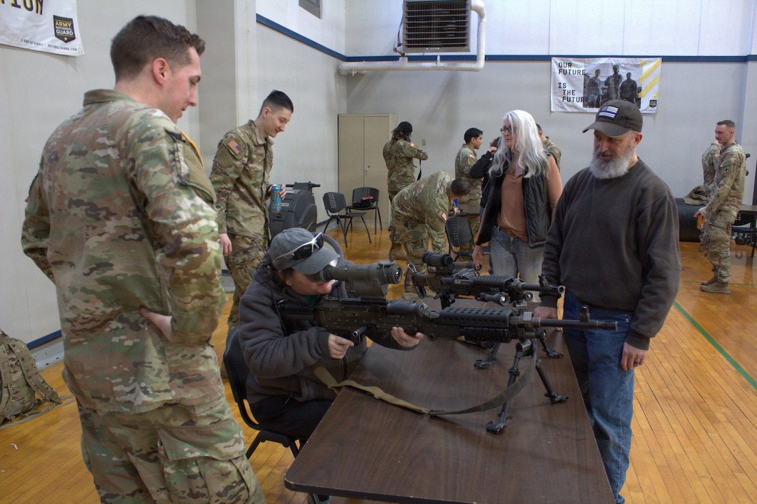 Soldiers of Alpha Battery, 2nd Battalion, 122nd Field Artillery Regiment show members of the local community how to use a 240B, squad automatic weapon, with optics on it at the Sycamore Armory.