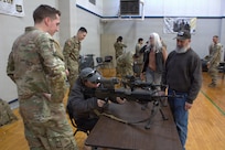 Soldiers of Alpha Battery, 2nd Battalion, 122nd Field Artillery Regiment show members of the local community how to use a 240B, squad automatic weapon, with optics on it at the Sycamore Armory.