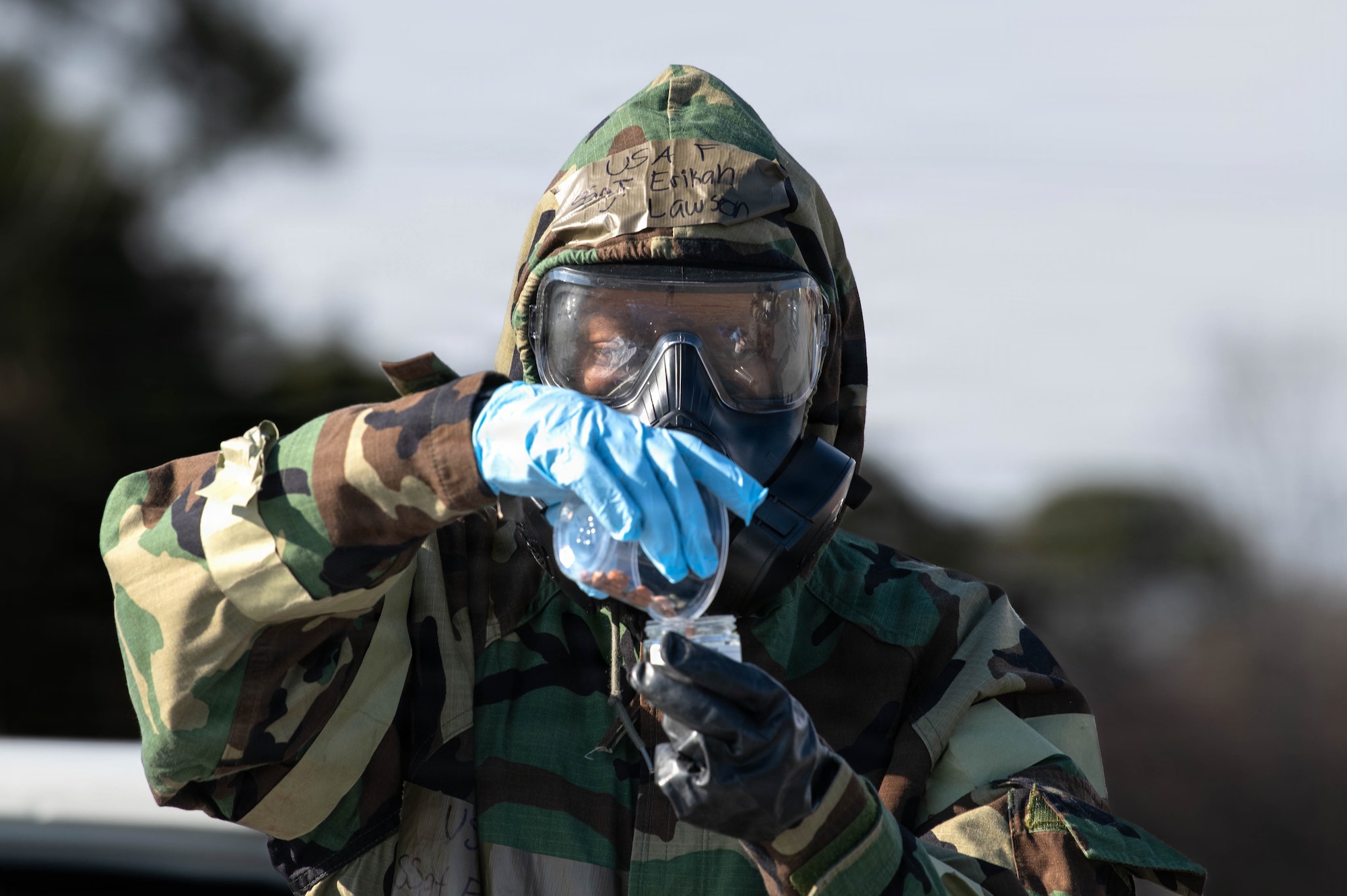 Airman collects a sample of a simulated hazardous substance