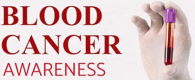 Hand holding a tube of blood.