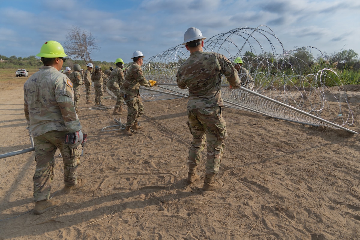 Service members construct anti-climb barriers