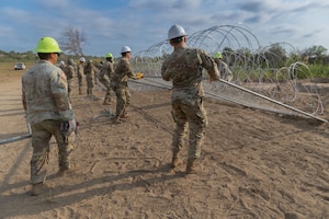 Service members construct anti-climb barriers