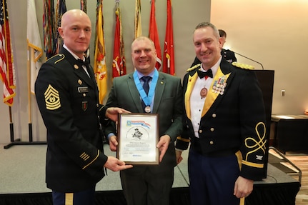 Brigade Command Sgt. Maj. Michael Filipiak and Col. Michael R. Kowalski, commander of the 33rd Infantry Brigade Combat Team, stand with Master Sgt. Aaron M. Bogacz after he received the Knowlton Award during the 33rd Infantry Brigade Combat Team military ball.