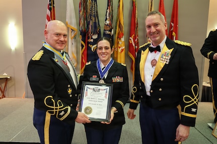 Col. Michael R. Kowalski and Col. Seth Hible present Chief Warrant Officer 3 Jennifer M. Rosa with the Col. Robert L. Manning Achievement Medal .