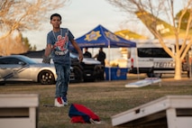 boy plays corn hole game