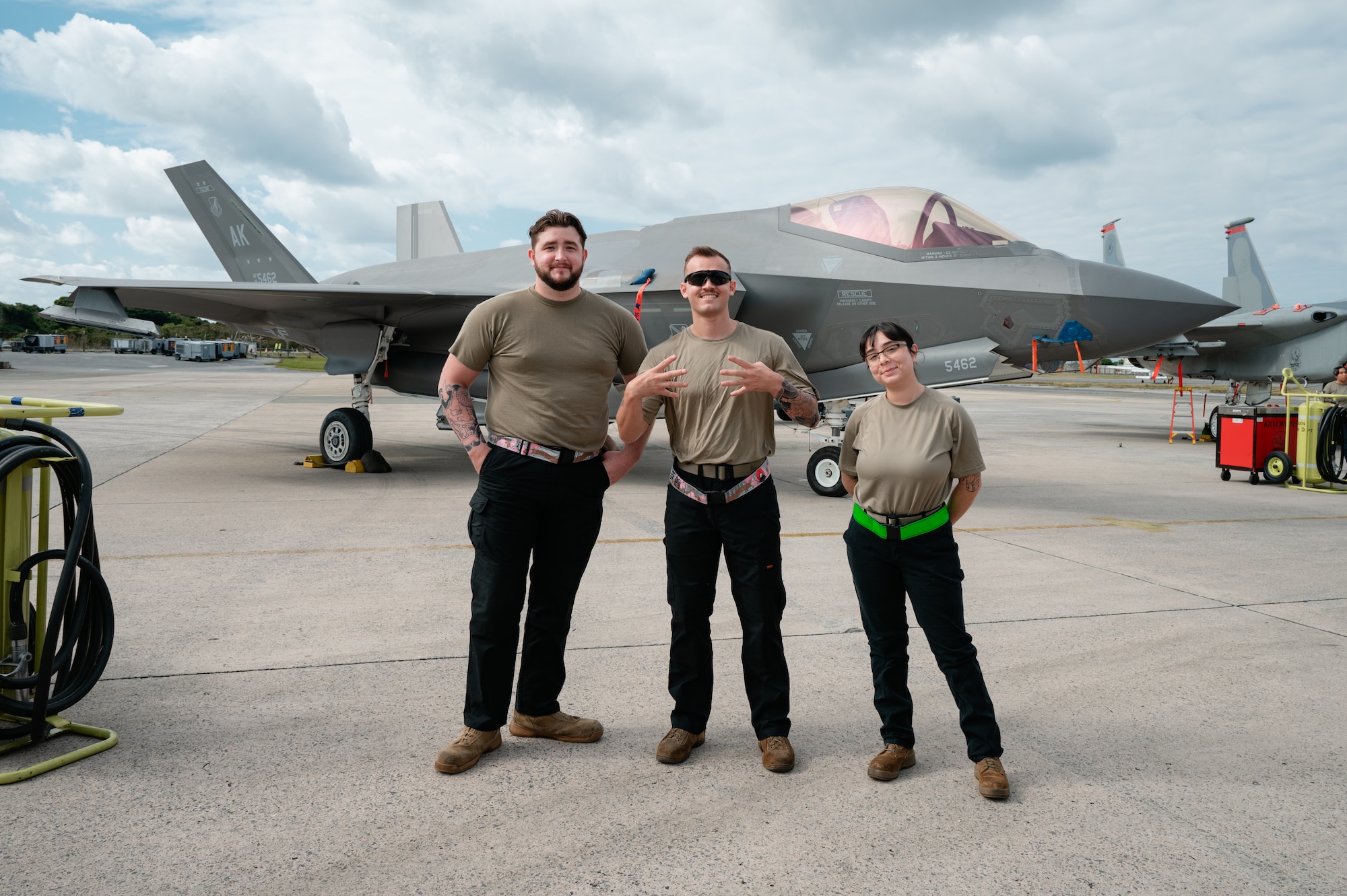 U.S. Air Force Staff Sgt. Trystan Speakes, left, 356th Fighter Generation Squadron  
weapons load crew chief, Senior Airman Joshua Chabot, center, and Airman 1st Class Michelle Rios, 356 FGS weapons load crew members, deployed to Kadena Air Base, pose in front of an F-35A Lightning II deployed to Kadena Air Base, during the 18th Wing Load Crew of the Quarter Competition at Kadena Air Base, Japan, Jan. 30, 2026. Through weapons load competitions, Airmen reinforce mission readiness and ensure credible global strike power. (U.S. Air Force photo by Airman 1st Class Francisco Huerta)