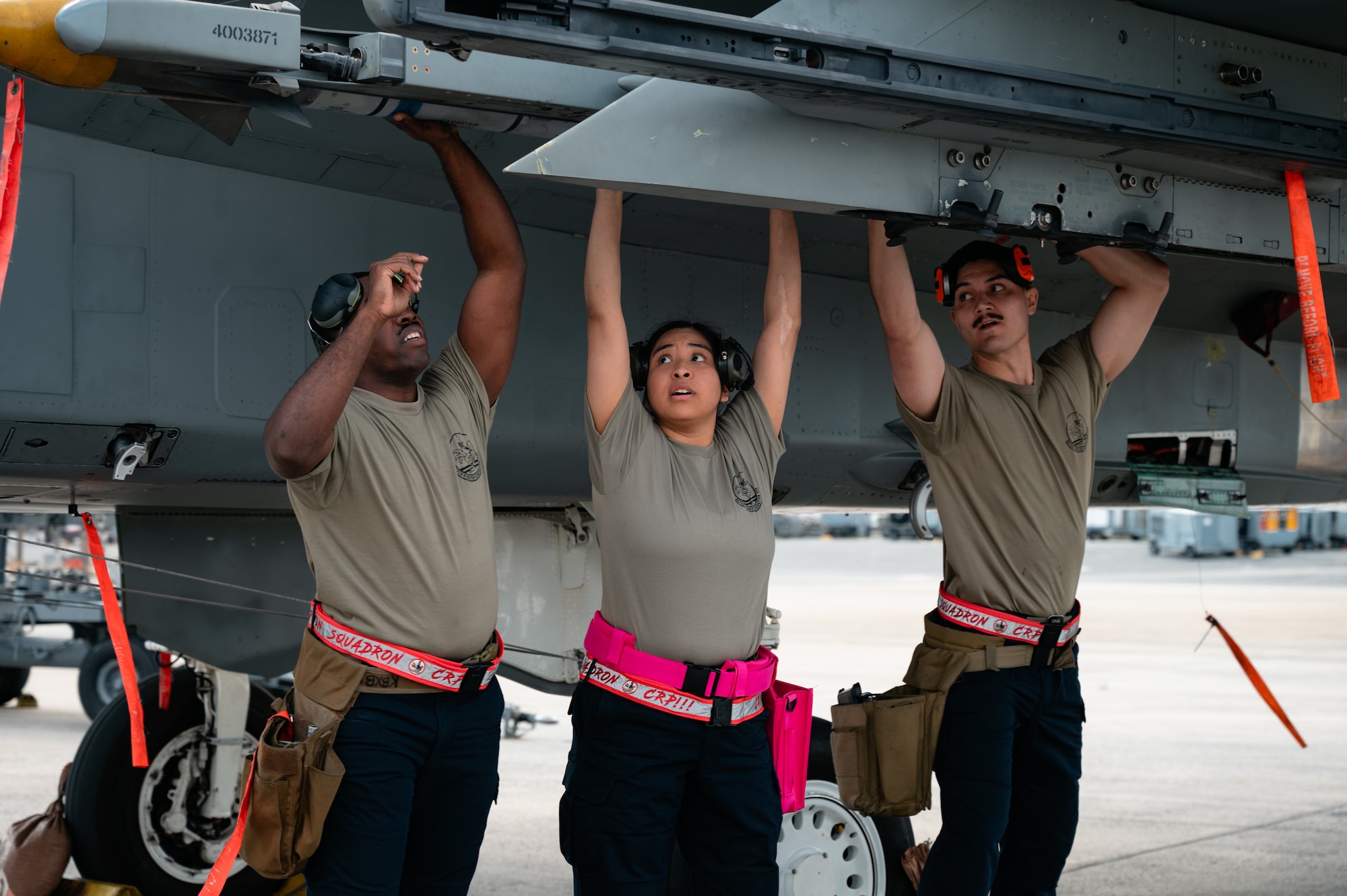 U.S. Air Force Senior Airman Elijah Armstrong, left, 67th Fighter Generation Squadron  
weapons load crew member, Senior Airman Ana Tejada, center, 67th FGS weapons load crew member and Staff Sgt. Randal Garcia, 67th FGS weapons load crew chief, load munitions onto an F-15E Strike Eagle during the 18th Wing Load Crew of the Quarter Competition at Kadena Air Base, Japan, Jan. 30, 2026. By mastering weapons loading procedures, Airmen enhance mission readiness and uphold global strike deterrence. (U.S. Air Force photo by Airman 1st Class Francisco Huerta)