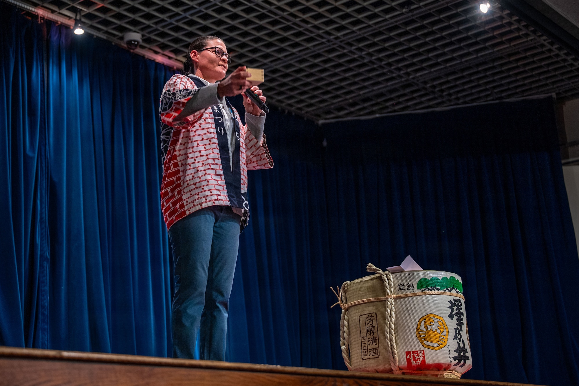 A person on stage next to a barrel