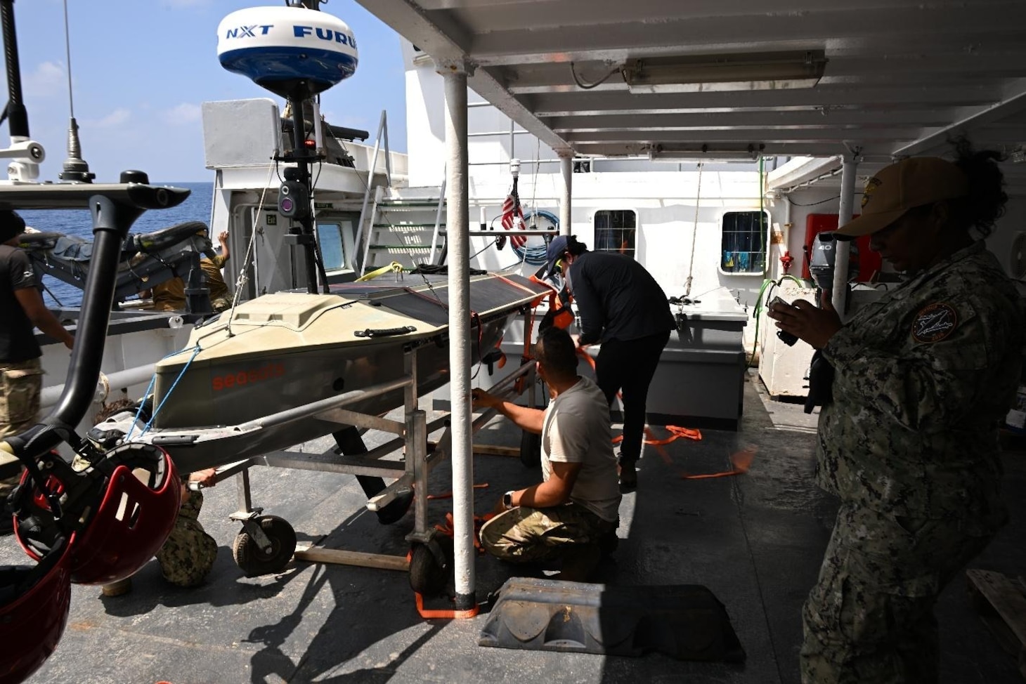 OS2 Melissa Adams and Shane Condon,with Task Force 66 and Seychelles Coast Guardsman Captain Julian Morel prepare the launch of  the Lightfish, an unmanned surface vessel (USV), marking for the first time the system has been deployed from a partner surface vessel, as part of Cutlass Express 2026 (CE 26).