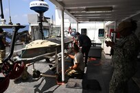OS2 Melissa Adams and Shane Condon,with Task Force 66 and Seychelles Coast Guardsman Captain Julian Morel prepare the launch of  the Lightfish, an unmanned surface vessel (USV), marking for the first time the system has been deployed from a partner surface vessel, as part of Cutlass Express 2026 (CE 26).