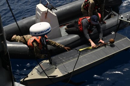 Shane Condon, a civilian contractor with Task Force 66 and a Seychelles Coast Guardsmen launch the Lightfish, an Unmanned Surface Vessel (USV), marking for the first time the system has been deployed from a partner surface ship during Cutlass Express 2026 (CE 26).