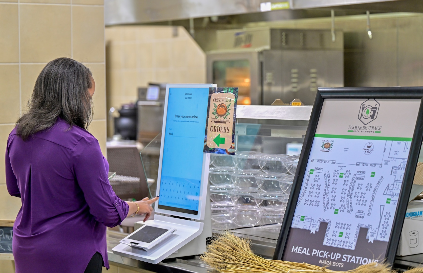 A customer orders a meal that will be delivered by a robot at DSCR. The robot is one of two deployed by FMWR as part of a pilot program.