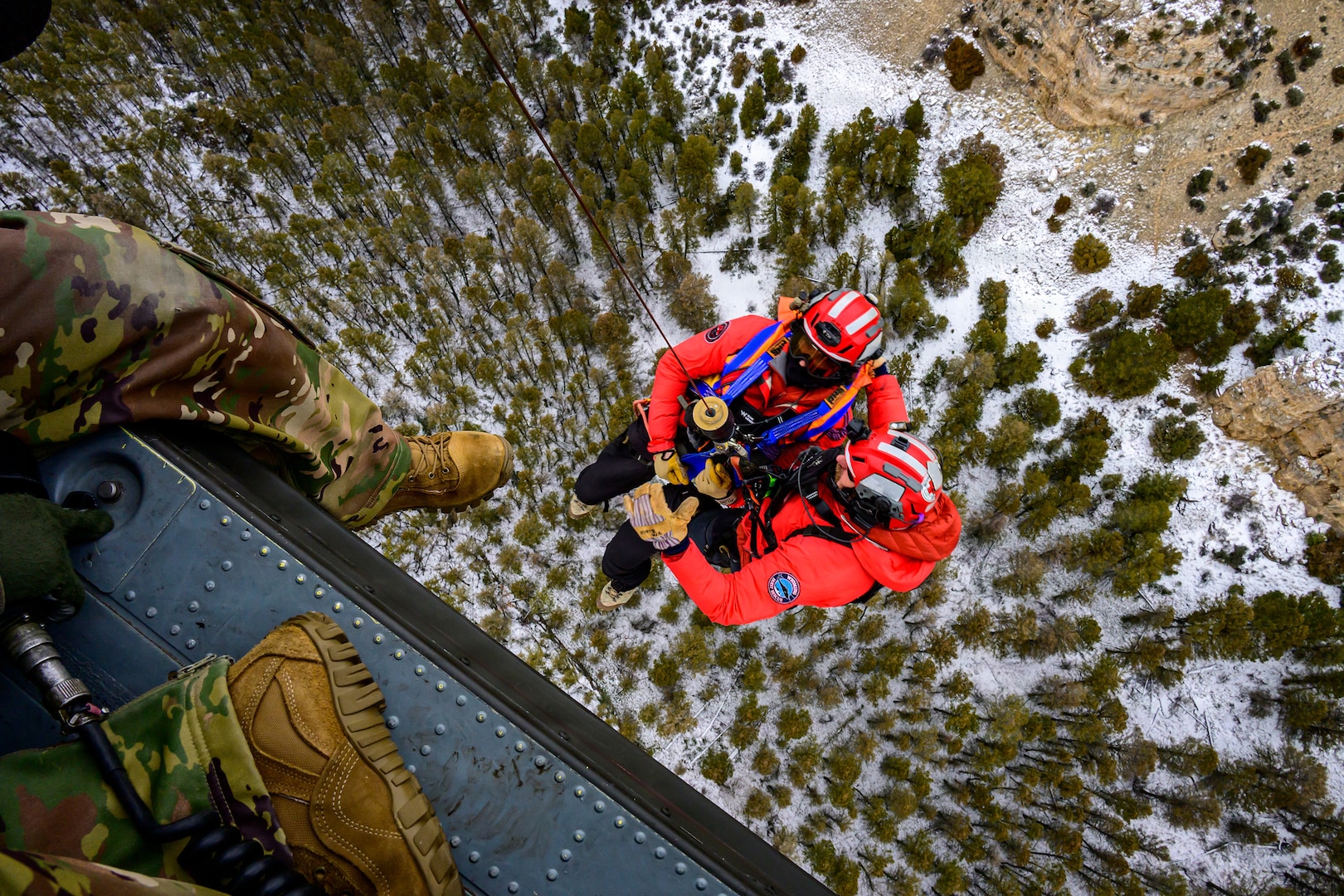 Members from the Big Horn County Search and Rescue Team are raised toward a UH-60 Black Hawk helicopter as a Wyoming Army National Guard crew member looks down during hoist training in the Greybull Mountains in Wyoming, Jan. 28, 2026.