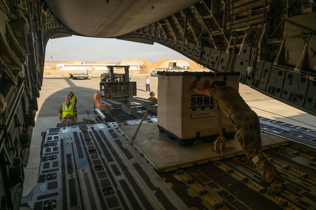 U.S. Air Force Senior Airman Kaitlyn Hicks, 16th Expeditionary Airlift Squadron loadmaster, pushes a cargo pallet off of a C-17 Globemaster III aircraft in the U.S. Central Command area of responsibility, Jan. 08, 2006. Hicks was deployed to provide the safe and efficient loading of cargo and personnel onboard the Globemaster throughout the CENTCOM AOR. (U.S. Air Force photo by Tech. Sgt. Nicholas Monteleone)