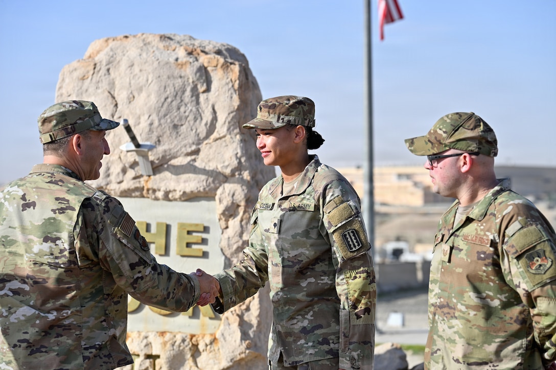 U.S. Air Force Col. Nathan Aysta, 386th Air Expeditionary Wing commander, coins U.S. Army Spc. Carla Coleman, 1st Theater Sustainment Command customs border and clearance agent, at a base within the U.S. Central Command area of responsibility, Feb. 2, 2026. Coleman contributed over 150 hours of volunteer work that extended beyond the mission, demonstrating a commitment to service that positively affected fellow servicemembers. (U.S. Air Force photo by Staff Sgt. Tylin Rust)