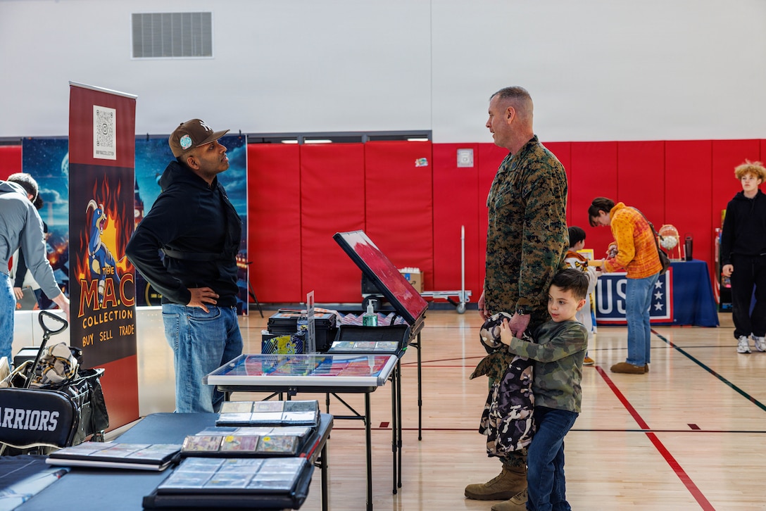 U.S. Marine Corps Sgt. Maj. Liam Williams, the Base Sergeant Major of Marine Corps Base Quantico, speaks to a vendor during MCB Quantico’s United Service Organization National Pokémon Day for the 30th Anniversary of Pokémon at the Quantico Middle/Highschool on Marine Corps Base Quantico, Feb. 7, 2026. This event was held to bring the community of MCB Quantico together with events including a scavenger hunt, card buying, battles and trading and a raffle. (U.S. Marine Corps photo by Lance Cpl. Donovan E. Melendez)