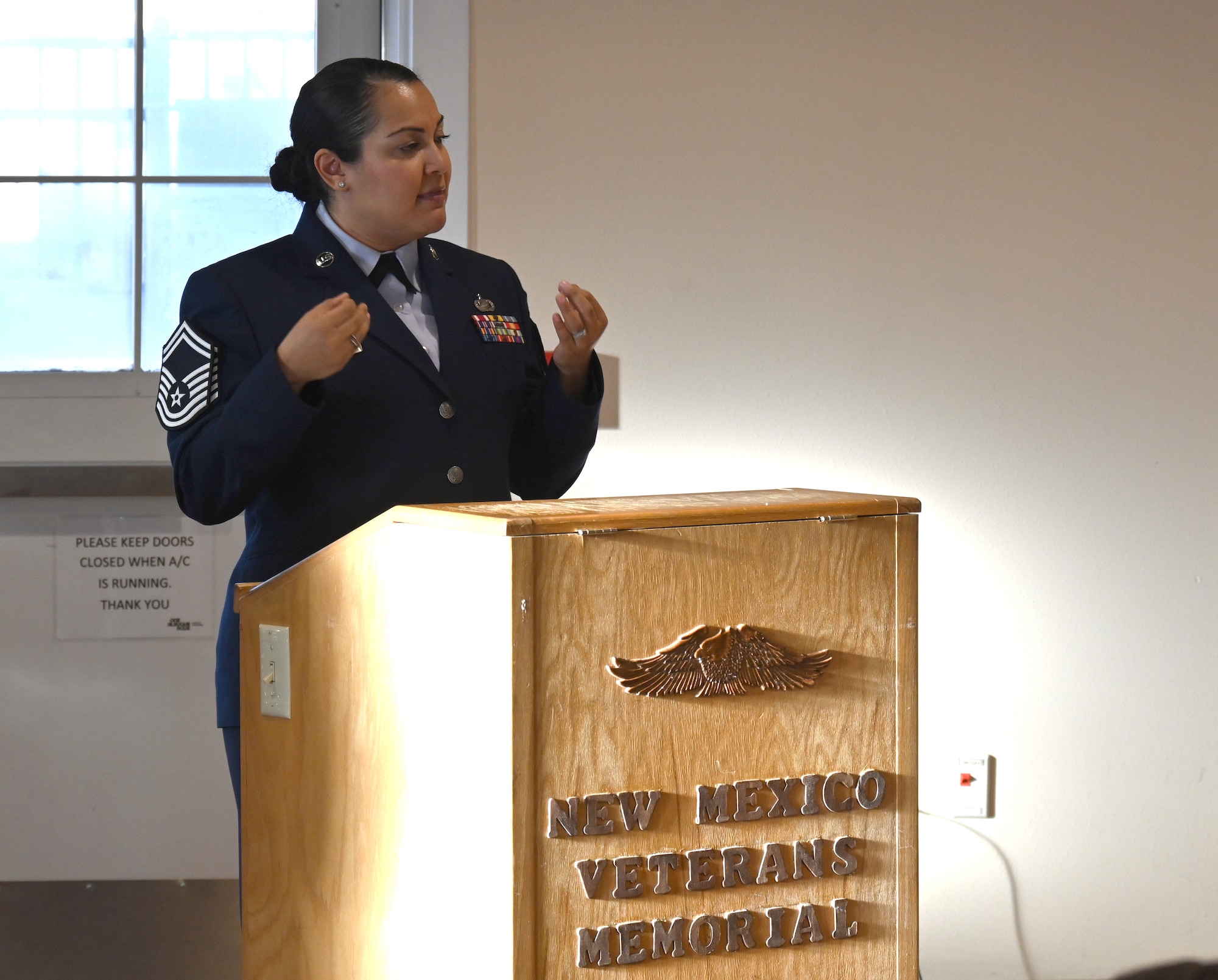 A woman in an Air Force dress uniform is at a podium addressing an audience