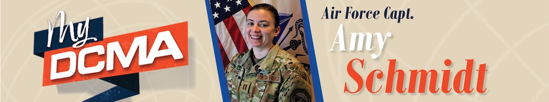 A smiling Amy Schmidt wears a military camouflage uniform while standing by the American flag