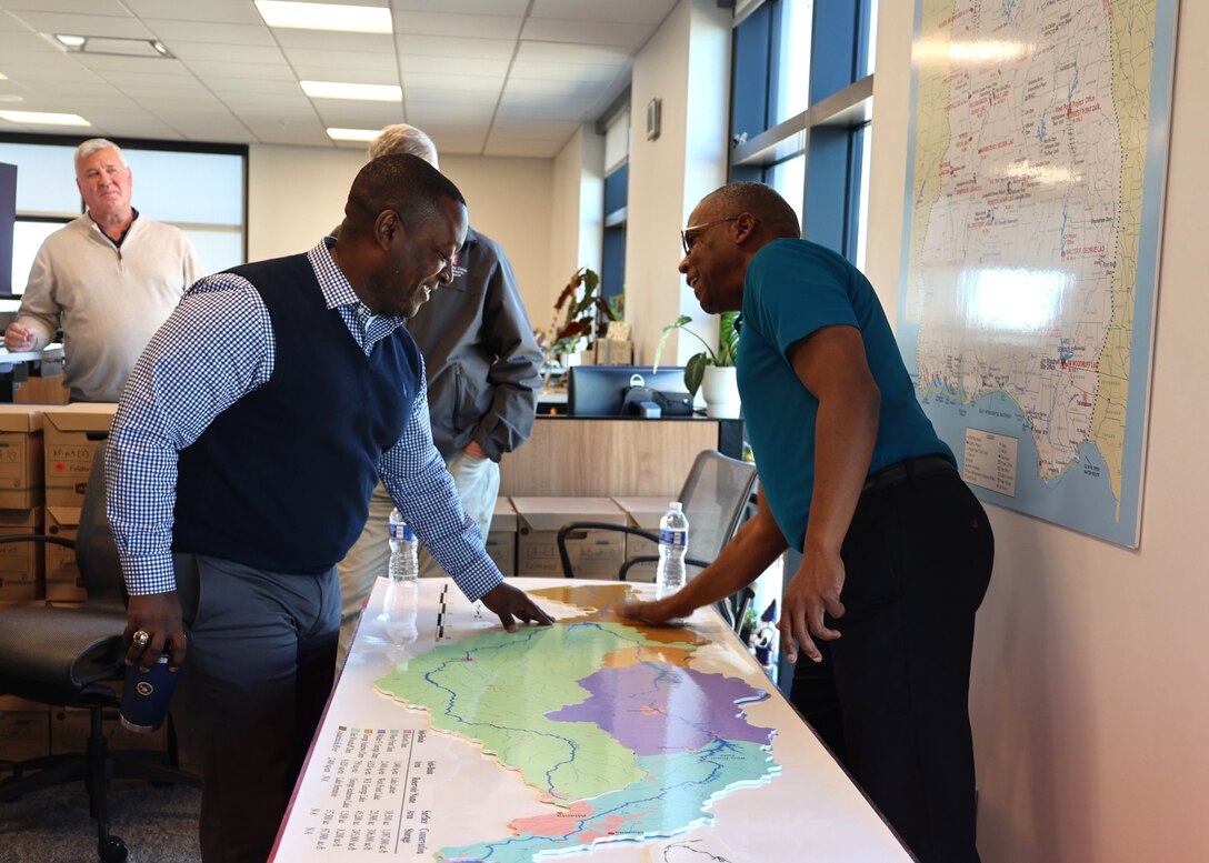 Two men pointing at a map