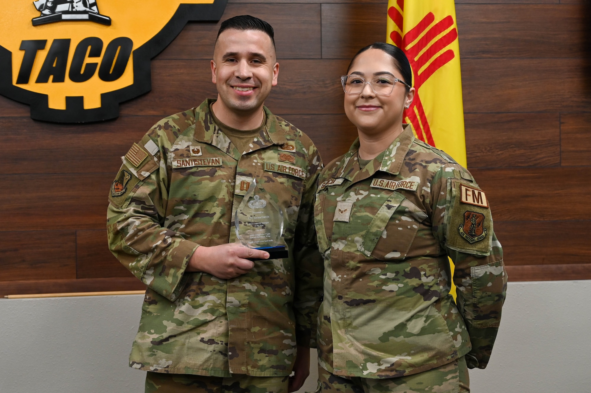 An Air Force captain and Airmen pose for a photo during an awards ceremony.