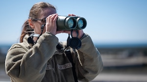 A Tyndall Airman looks through a laser range finder to measure height and distance of clouds and landmarks to help determine the altitude and distance of cloud formation.