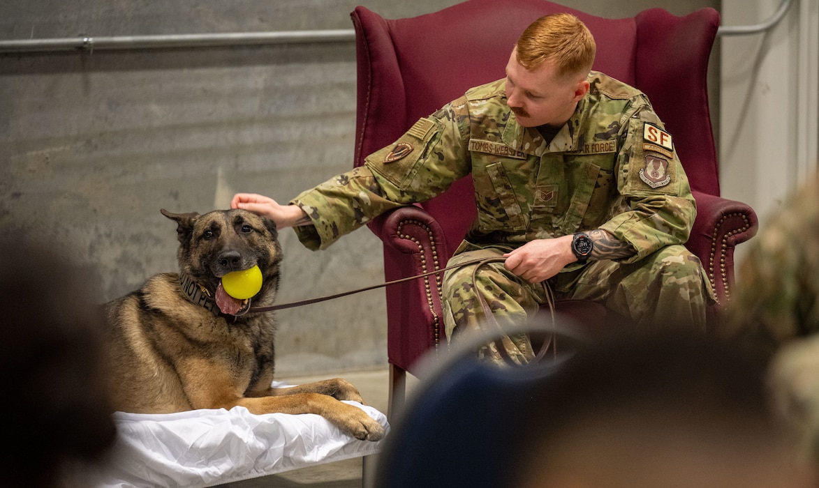 Staff Sgt. Ben Tombs-Webster, 88th Security Forces Dog Handler sits and celebrates Military Working Dog “Flex” and his retirement Feb. 9, 2026 at Wright-Patterson Air Force Base, Ohio, after serving for six and a half years. (U.S. Air Force by Jack Gardner) a half years. (U.S. Air Force by Jack Gardner)