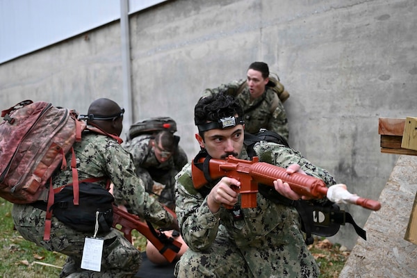 BETHESDA, Md. (Dec. 08, 2025)  – Hospital Corpsman 3rd Class Michael Bach, assigned Navy Medicine Readiness and Training Command (NMRTC) Bethesda, provides security for his team while they provide emergency care as part of the Tactical Combat Casualty Care (TCCC) Tier 1 course assessment. The testing marks the culmination of the 63-hour Combat Medic/Corpsman TCCC course, which prepares Navy corpsmen and other military medical personnel to deliver lifesaving trauma care in austere, forward-deployed, and combat environments. NMRTC Bethesda mission is to maximize warfighter performance through optimized medical readiness tailored to operational requirements; enhance the readiness of the medical force to sustain expeditionary medical capability; and train and develop the Navy Medicine Force. (U.S. Navy photo by Mass Communication Specialist 2nd Class Alec Kramer)