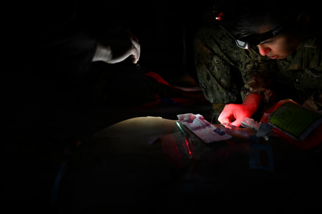 BETHESDA, Md. (Dec. 08, 2025) - Lt. Simon Choi, assigned Navy Medical Readiness and Training Command (NMRTC) Bethesda, who serves as the Assistant Service Chief at the Medicine Intensive Care Unit, at Walter Reed National Military Medical Center (WRNMMC) provides emergency care as part of the Tactical Combat Casualty Care (TCCC) Tier 1 course assessment. The testing marks the culmination of the 63-hour Combat Medic/Corpsman TCCC course, which prepares Navy corpsmen and other military medical personnel to deliver lifesaving trauma care in austere, forward-deployed, and combat environments. NMRTC Bethesda mission is to maximize warfighter performance through optimized medical readiness tailored to operational requirements; enhance the readiness of the medical force to sustain expeditionary medical capability; and train and develop the Navy Medicine Force. (U.S. Navy photo by Mass Communication Specialist 2nd Class Alec Kramer)