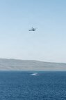 An AH-1Z Viper with Marine Medium Tiltrotor Squadron (VMM) 163 (Reinforced), 11th Marine Expeditionary Unit, flies over simulated adversary vessels approaching San Antonio-class amphibious transport dock ship USS Portland (LPD 27) during a simulated strait transit in the Pacific Ocean, Jan. 27, 2026. The simulated strait transit was conducted to refine the 11th Marine Expeditionary Unit’s ability to integrate with the Navy for enhanced force protection. The 11th MEU is currently underway aboard the Boxer Amphibious Ready Group in the U.S. 3rd Fleet area of operations conducting integrated training that enhances lethality and warfighting readiness. (U.S. Marine Corps photo by Lance Cpl. Luke Rodriguez)