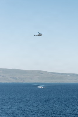 An AH-1Z Viper with Marine Medium Tiltrotor Squadron (VMM) 163 (Reinforced), 11th Marine Expeditionary Unit, flies over simulated adversary vessels approaching San Antonio-class amphibious transport dock ship USS Portland (LPD 27) during a simulated strait transit in the Pacific Ocean, Jan. 27, 2026. The simulated strait transit was conducted to refine the 11th Marine Expeditionary Unit’s ability to integrate with the Navy for enhanced force protection. The 11th MEU is currently underway aboard the Boxer Amphibious Ready Group in the U.S. 3rd Fleet area of operations conducting integrated training that enhances lethality and warfighting readiness. (U.S. Marine Corps photo by Lance Cpl. Luke Rodriguez)