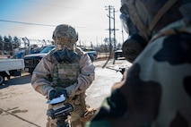An Airman dressed in personal protective chemical equipment conducts a chemical check.
