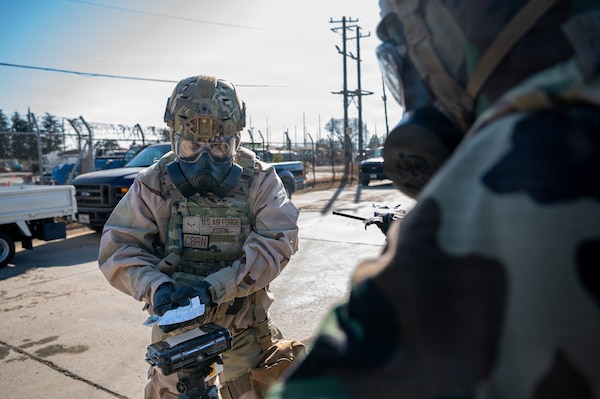 An Airman dressed in personal protective chemical equipment conducts a chemical check.