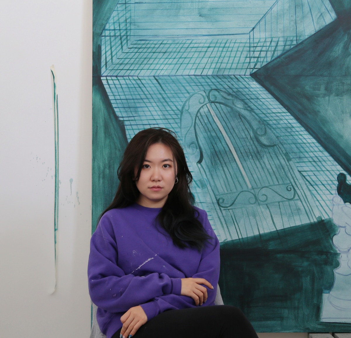 Jingqi Steinhiser, Misawa Club events coordinator and military spouse, poses in front of one of her paintings at her art studio at Misawa, Japan, 2025.