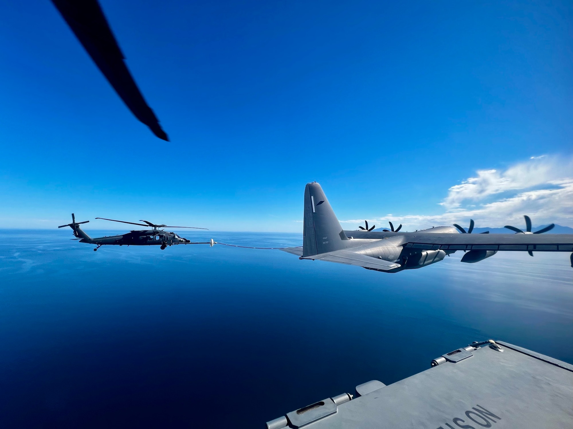 U.S. Air Force aircraft from the 563rd Rescue Group perform air-to-air refueling during a rescue mission.