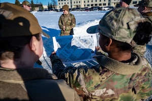 U.S. Air Force Tech. Sgt. Alexis Walker, 611th Civil Engineer Squadron operations manager, uses a map during the land navigation training of the Mission Ready Airman training portion of the Professional Development Center’s Noncommissioned Officer Foundation Course 500 at Joint Base Elmendorf-Richardson, Alaska, Feb. 6, 2026. Land navigation exercises prepare Airmen to maintain mission effectiveness when GPS or communications are limited. (U.S. Air Force photo by Senior Airman Hunter Hites)