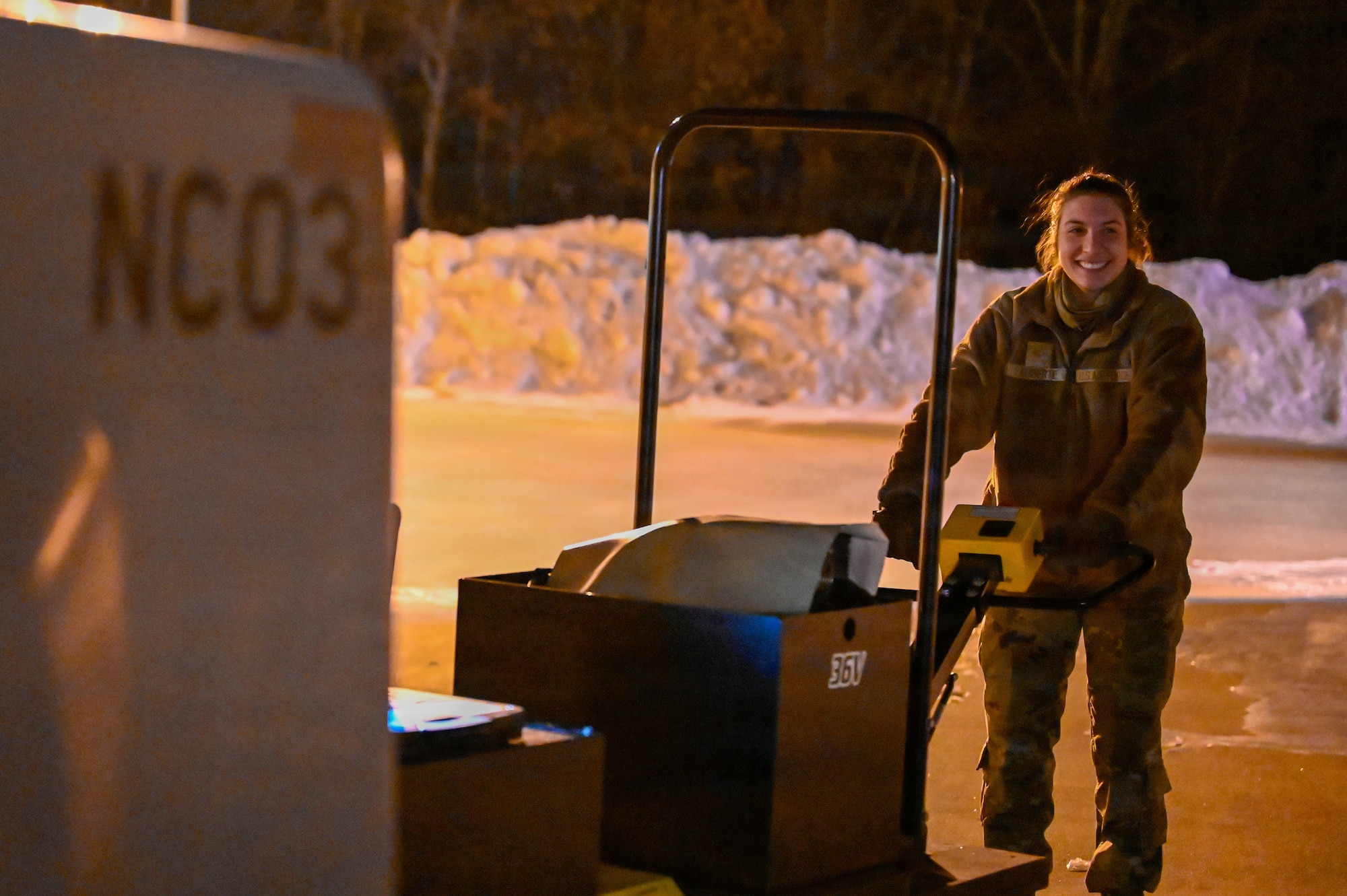 Airman moves equipment in the snow