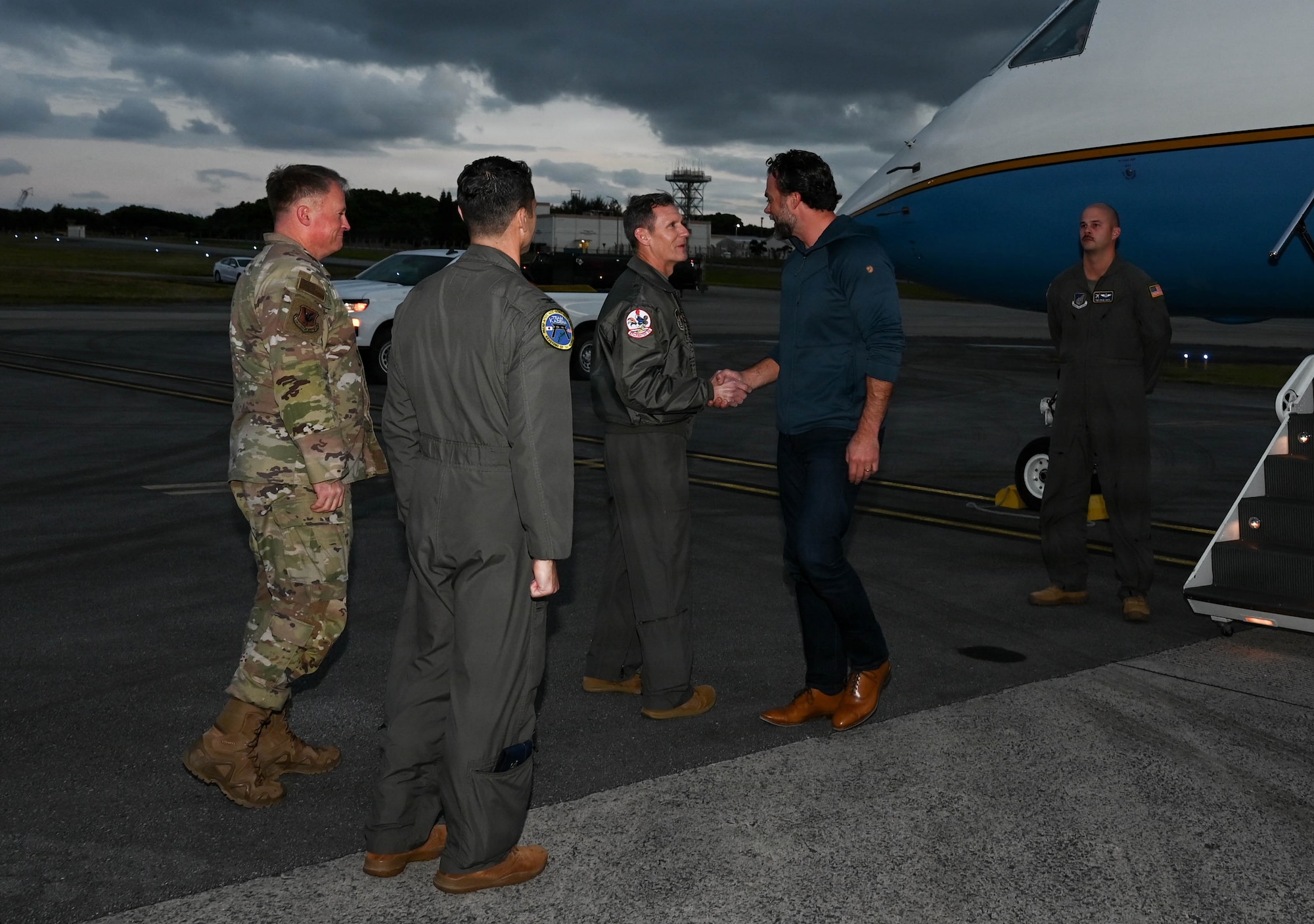 Service members greet government official.