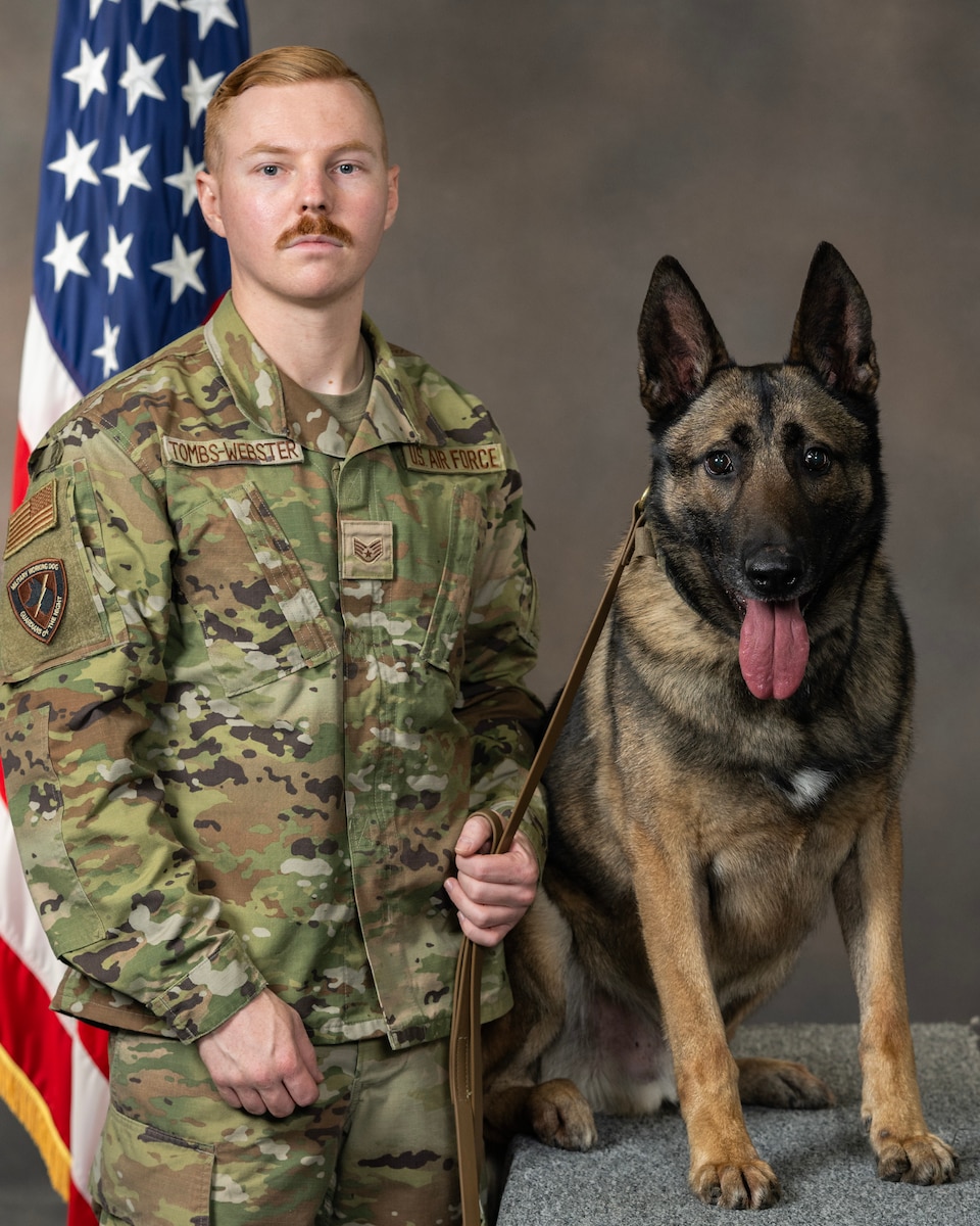 Staff Sgt. Ben Tombs-Webster, 88th Security Forces Squadron miliary working dog handler, and MWD Flex, stand for their official portrait