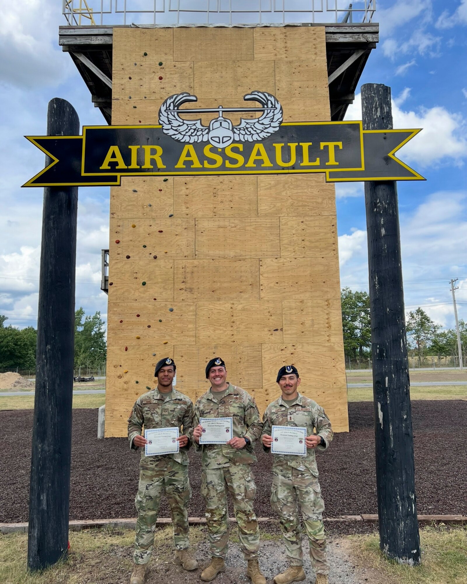 U.S. Air Force (from left to right), Senior Airman James Daniels, a patrolman with the 11th Security Forces Squadron, Staff Sgt. Zachary Lee Artibee, non-commissioned officer in charge of research and analysis with the 11th SFS, and 2nd Lt. Juan Garcia, flight commander for the 11th SFS, pose in front of the Air Assault Wall at the U.S. Army’s Sabalauski Air Assault School, Fort Campbell, Tenn., Sept. 1, 2025. These Airmen earned the U.S. Army’s Air Assault Badge, which focused on combat and air operations over 10 days of instruction. The course included tactical training, rappelling, written assessments and a 12-mile ruck march. (Courtesy photo provided by U.S. Air Force Staff Sergeant Zachary Artibee)