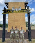 U.S. Air Force (from left to right), Senior Airman James Daniels, a patrolman with the 11th Security Forces Squadron, Staff Sgt. Zachary Lee Artibee, non-commissioned officer in charge of research and analysis with the 11th SFS, and 2nd Lt. Juan Garcia, flight commander for the 11th SFS, pose in front of the Air Assault Wall at the U.S. Army’s Sabalauski Air Assault School, Fort Campbell, Tenn., Sept. 1, 2025. These Airmen earned the U.S. Army’s Air Assault Badge, which focused on combat and air operations over 10 days of instruction. The course included tactical training, rappelling, written assessments and a 12-mile ruck march. (Courtesy photo provided by U.S. Air Force Staff Sergeant Zachary Artibee)