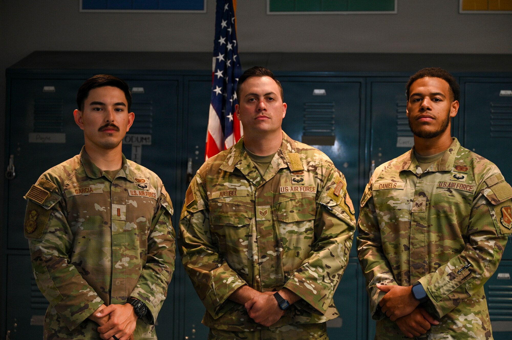 U.S. Air Force (from left to right), 2nd Lt. Juan Garcia, flight commander for the 11th Security Forces Squadron, Staff Sgt. Zachary Lee Artibee, non-commissioned officer in charge of research and analysis with the 11th SFS, and Senior Airman James Daniels, a patrolman with the 11th SFS, pose in front of a flag at Joint Base Anacostia-Bolling, Washington, D.C., Sept. 19, 2025. These Airmen earned the U.S. Army’s Air Assault Badge, which focused on combat and air operations over 10 days of instruction. The course included tactical training, rappelling, written assessments and a 12-mile ruck march. (U.S. Air Force photo by Airman 1st Class Shanel Toussaint)