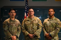 U.S. Air Force (from left to right), 2nd Lt. Juan Garcia, flight commander for the 11th Security Forces Squadron, Staff Sgt. Zachary Lee Artibee, non-commissioned officer in charge of research and analysis with the 11th SFS, and Senior Airman James Daniels, a patrolman with the 11th SFS, pose in front of a flag at Joint Base Anacostia-Bolling, Washington, D.C., Sept. 19, 2025. These Airmen earned the U.S. Army’s Air Assault Badge, which focused on combat and air operations over 10 days of instruction. The course included tactical training, rappelling, written assessments and a 12-mile ruck march. (U.S. Air Force photo by Airman 1st Class Shanel Toussaint)