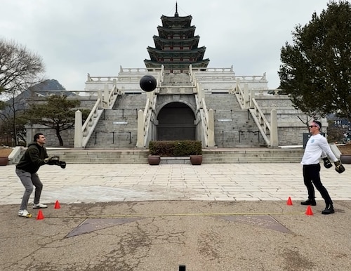 Capt. Adam Farah, left, throws a medicine ball to Maj. Jonathan Buckingham, to set the Guinness World Record for most catches of a medicine ball wearing boxing gloves in one minute, here Dec. 6, 2025. Buckingham has set a total of 17 Guinness World Records and has three currently pending. Buckingham is a program manager for Kessel Run, a division that is part of the Department of the Air Force Portfolio Acquisition Executive for Command, Control, Communication and Battle Management. Farah is a product manager with Kessel Run. (Courtesy image).