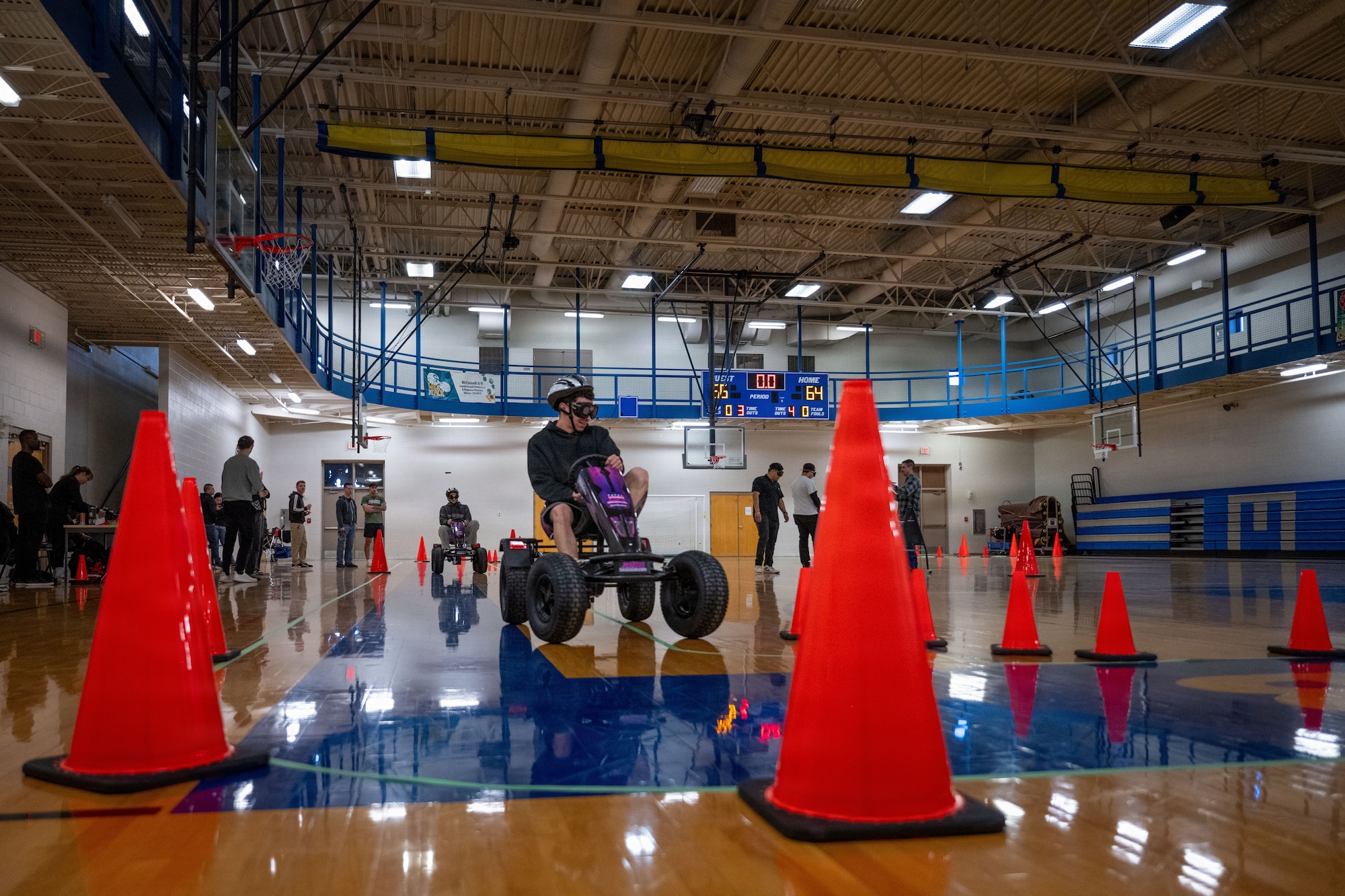 Members of Team McConnell navigate a non-motorized vehicle through a course while wearing impairment simulation goggles during Tanker Talks 2.0 at McConnell Air Force Base, Feb. 9, 2026. The activity was designed to demonstrate how alcohol and THC-related impairment can affect coordination, reaction time and decision-making in a controlled environment. (U.S. Air Force photo by Senior Airman Paula Arce)