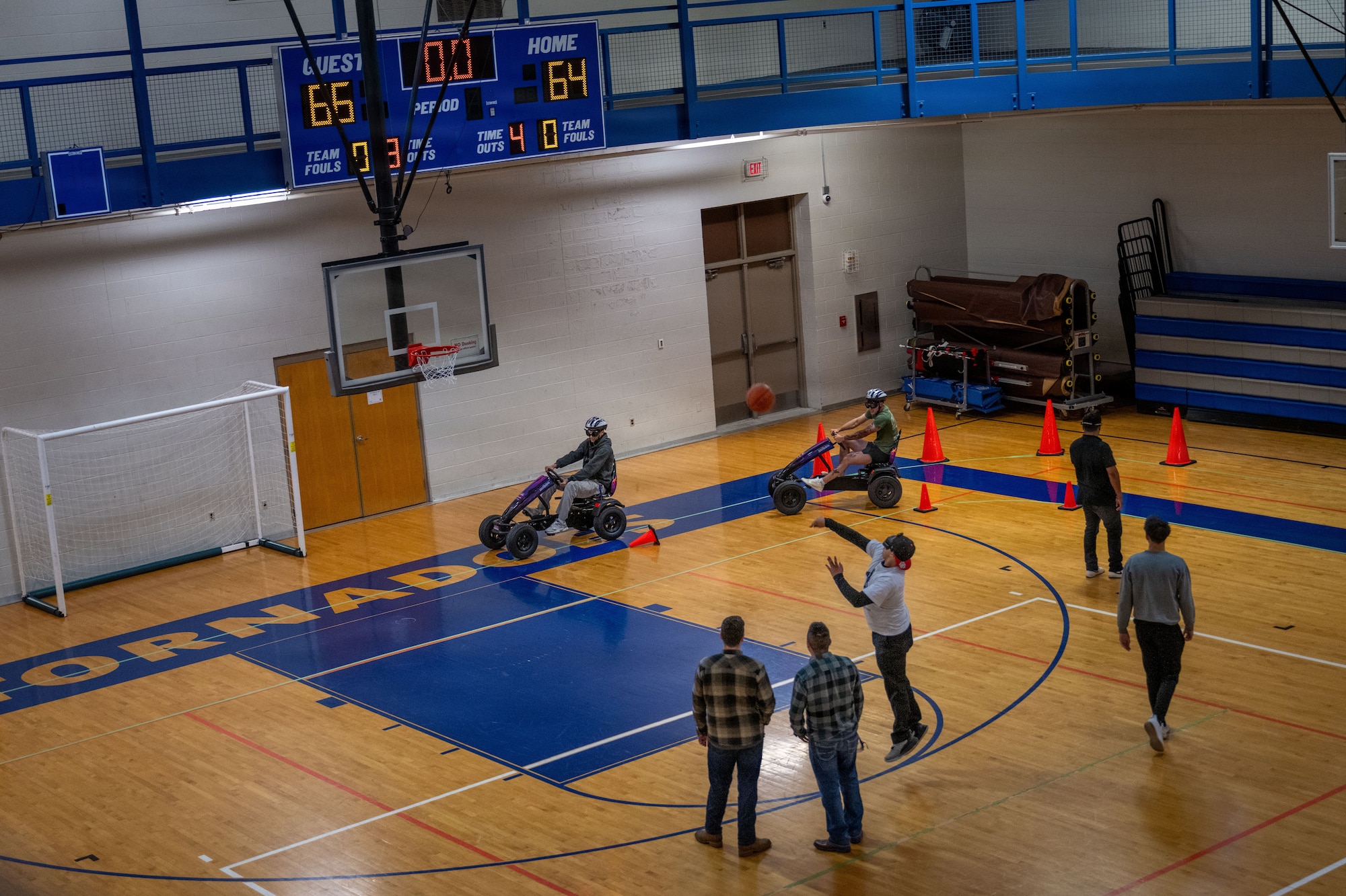 Members of Team McConnell navigate a non-motorized vehicle through a course and play basketball while wearing impairment simulation goggles during Tanker Talks 2.0 at McConnell Air Force Base, Feb. 9, 2026. The activity was designed to demonstrate how alcohol and THC-related impairment can affect coordination, reaction time and decision-making in a controlled environment. (U.S. Air Force photo by Senior Airman Paula Arce)
