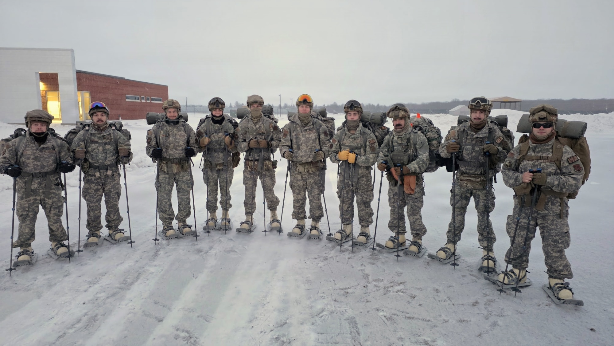 Airmen stand in the snow.