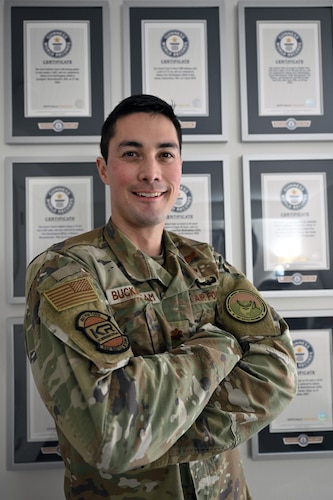 Maj. Jonathan Buckingham poses in front of a wall of Guinness World Records he achieved here, Feb. 4, 2026. Buckingham has set 17 Guinness World Records and has three submissions pending review. Buckingham is a program manager with the Department of the Air Force Portfolio Acquisition Executive for Command, Control, Communications and Battle Management’s Kessel Run division. (Official Air Force Photo by Richard Blumenstein).